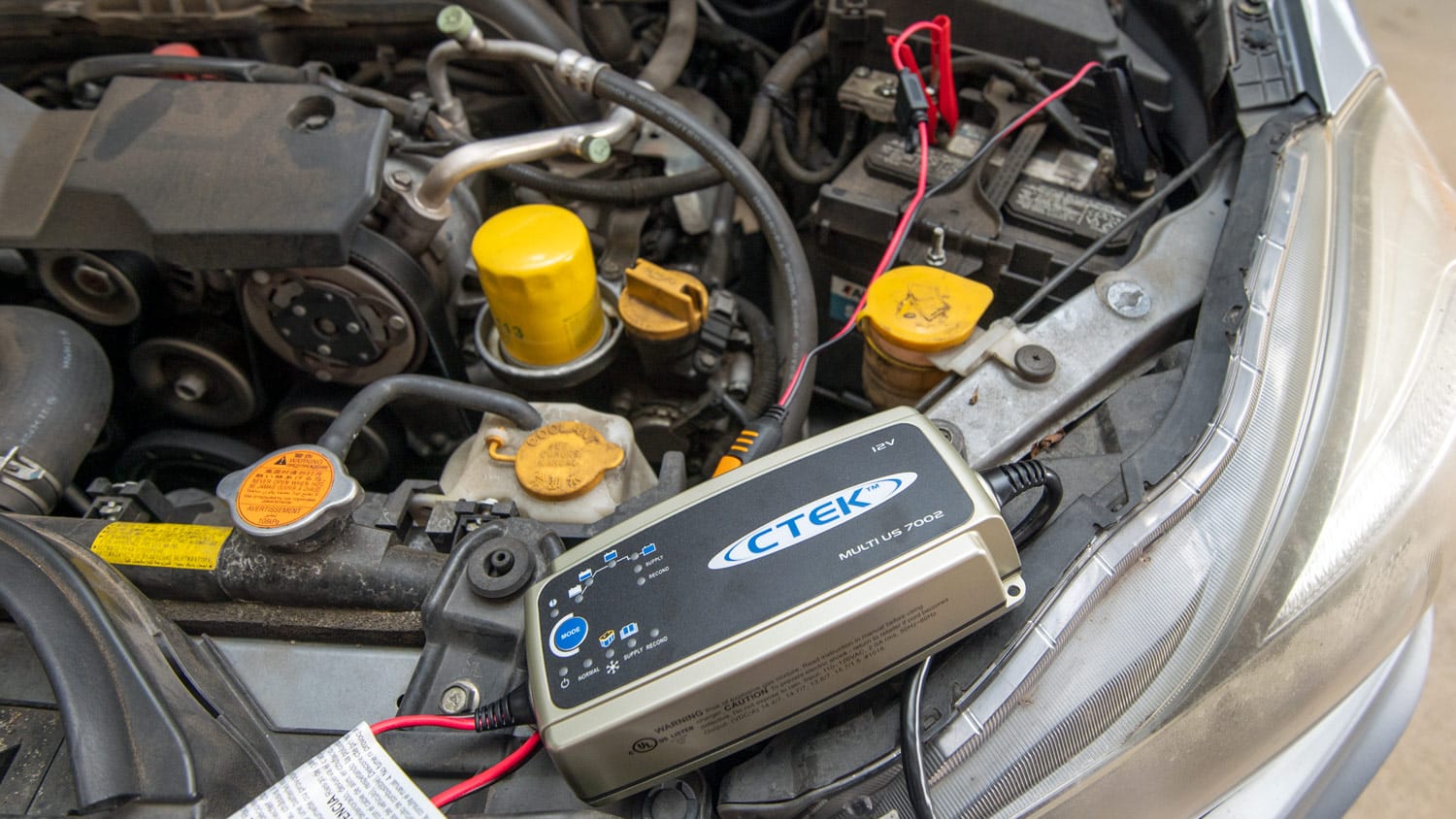 The CTEK car battery charger attached to a vehicle battery.