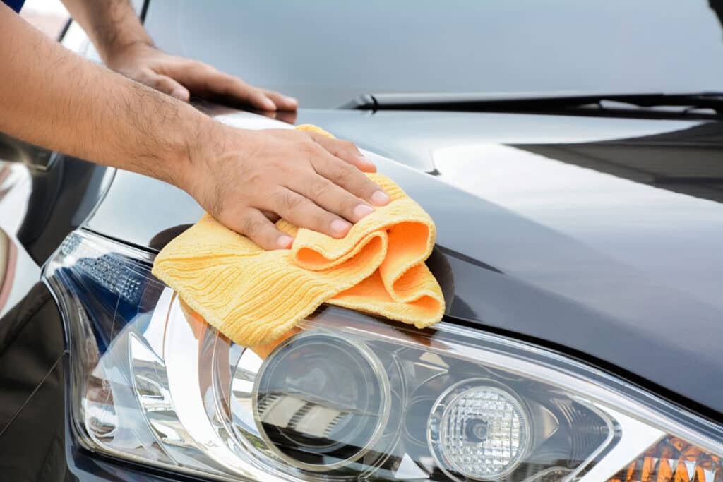 A man cleaning car with cloth, car detailing