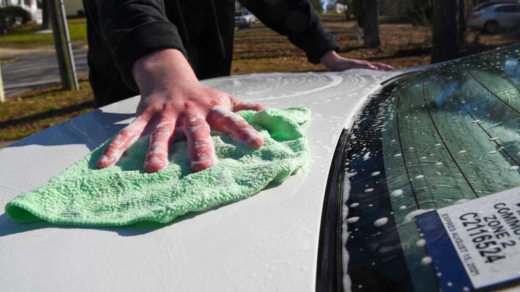 man cleaning car with sponge