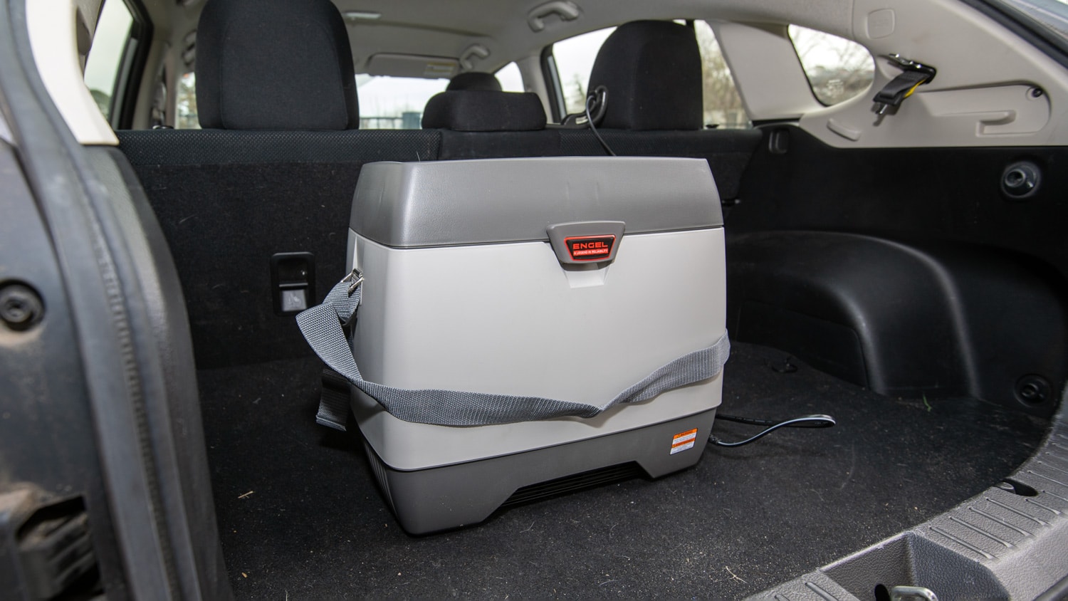 An Engel 14-quart 12-volt cooler sits in the back of a vehicle